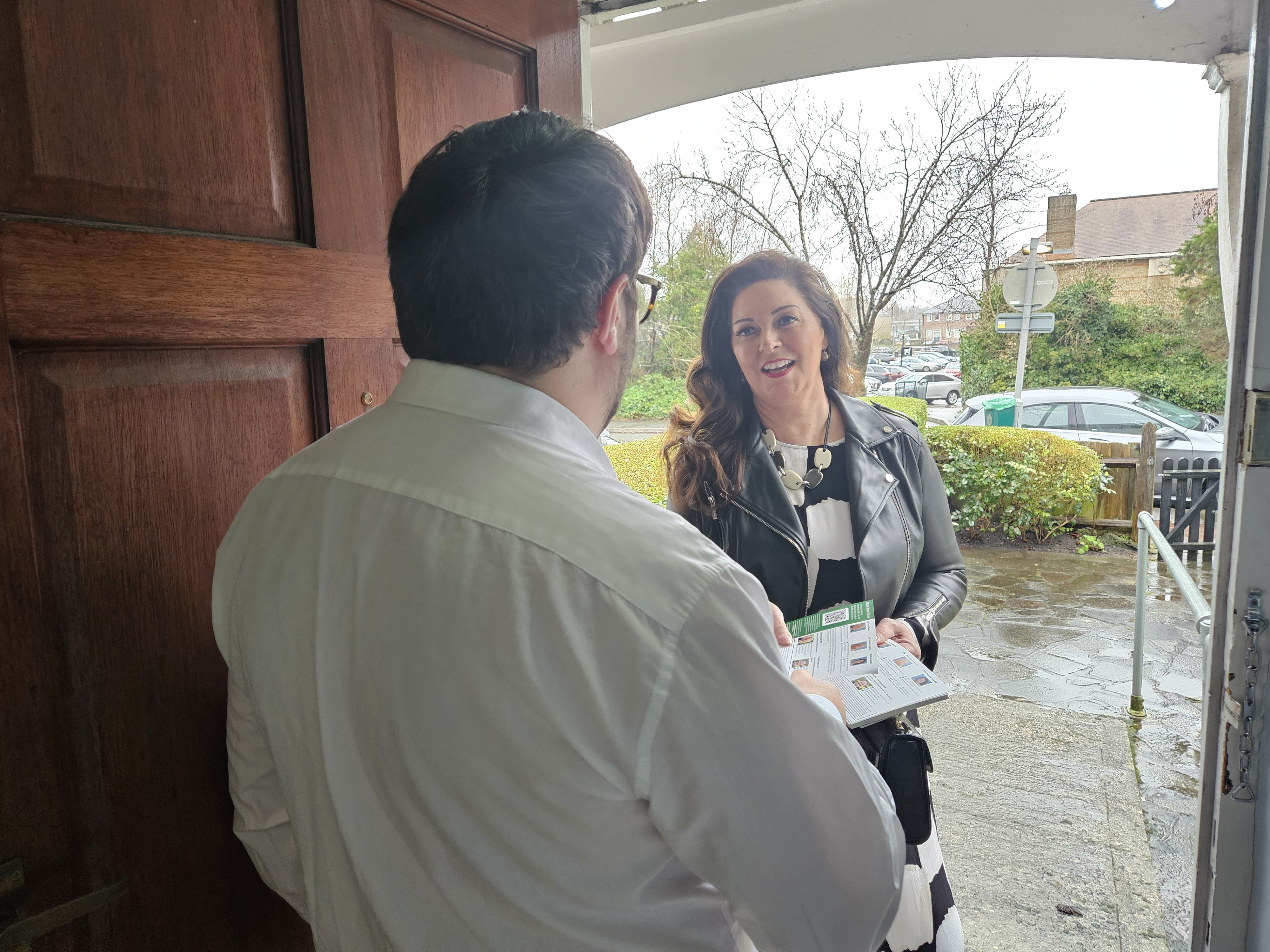Hannah talking to a constituent at door 