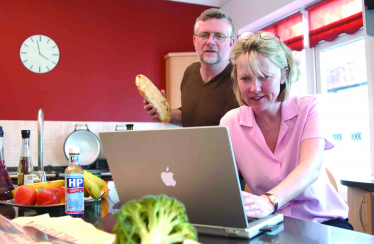 Coiple with computer in kitchen